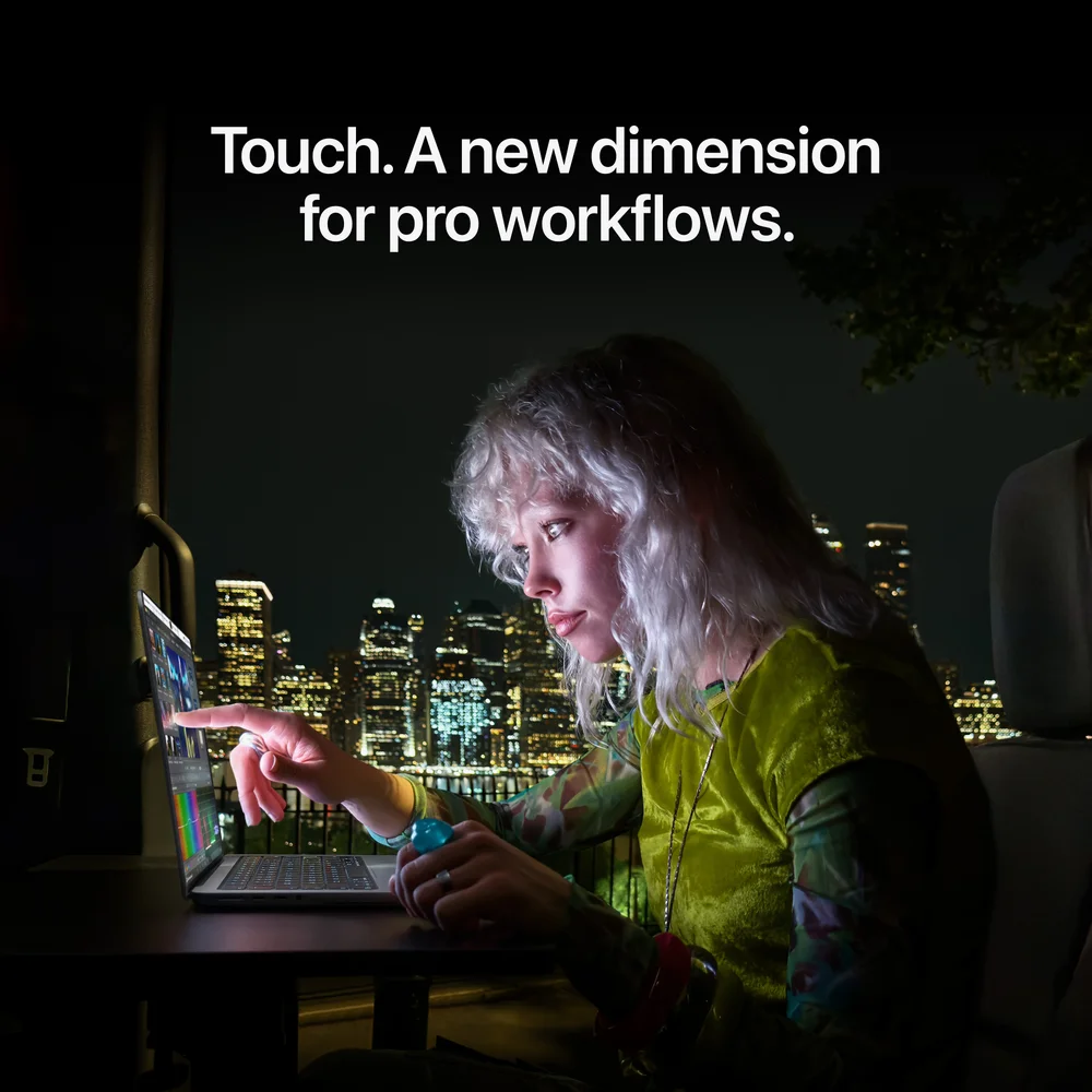 A person at night touching the screen of a MacBook Pro, with the words: Touch. A new dimension for pro workflows.