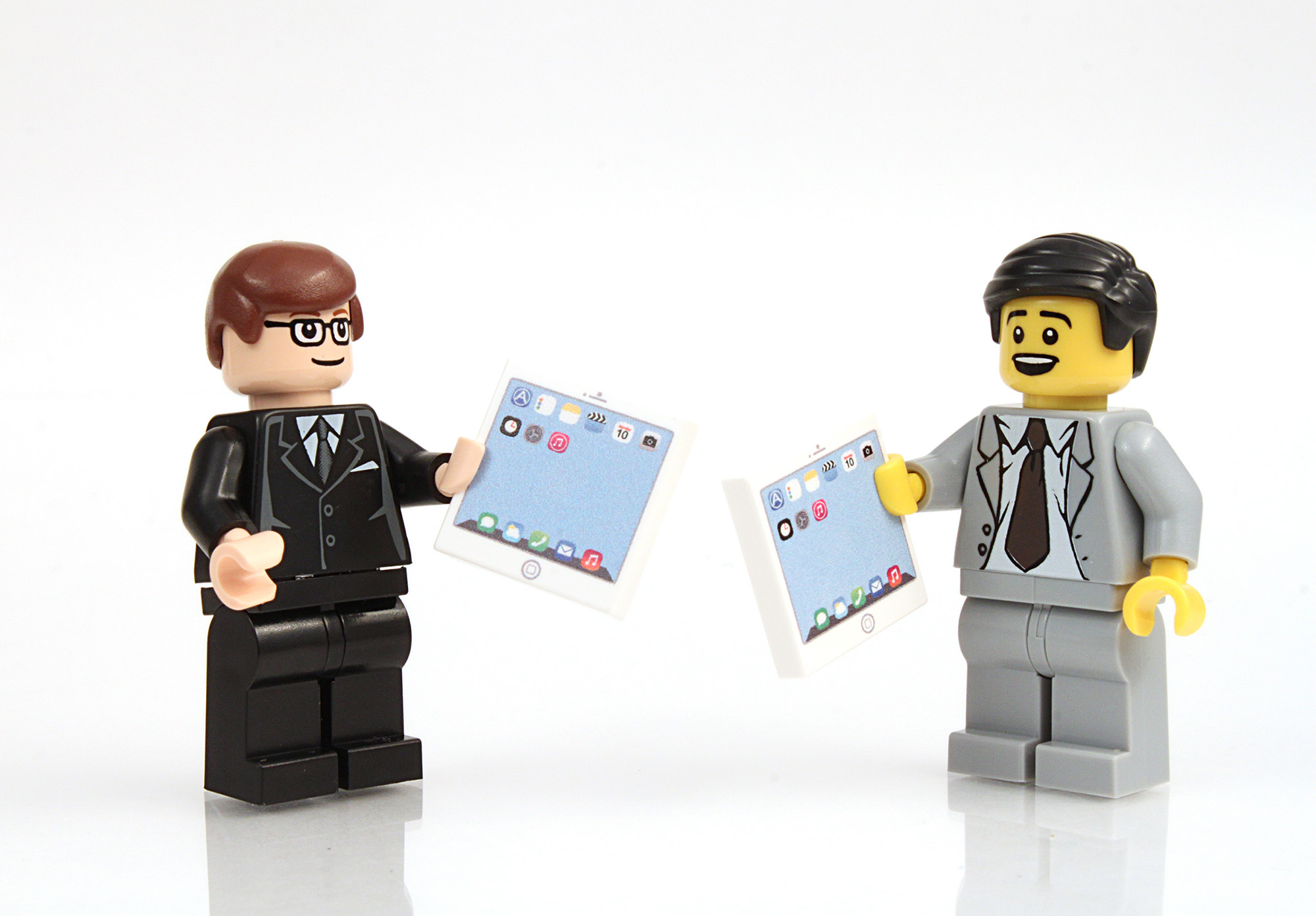 Comedy image of two Lego characters dressed in business suits holding what look like iPads